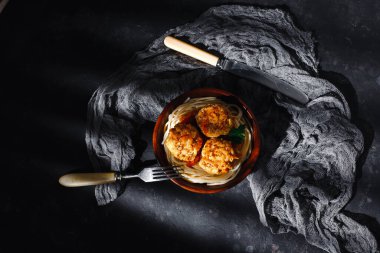 Beyaz soslu köfteli spagetti makarna, havuç ve soğanlı. Kırsal ahşap bir tabakta. Üst manzara, yan manzara. Etiket için yer.