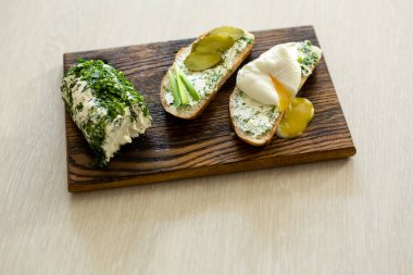 Ev yapımı, otlu, krem peynirli köy peyniri. Ev yapımı peynirli sandviç, salatalık turşusu, yeşil soğan ve yumurta. Üst görünüm, yan görünüm, metin alanı