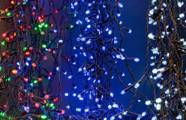 Gloeiende kerstslingers. Achtergrond met kerstverlichting. — Stockfoto