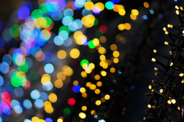 Defocused kerstslingers met kleurrijke gloed. Kerst achtergrond met veelkleurige bokeh. — Stockfoto