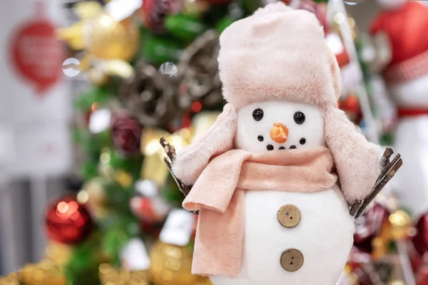 Noel ağacının arka planında bej şapkalı ve eşarplı Noel oyuncakları. — Stok fotoğraf