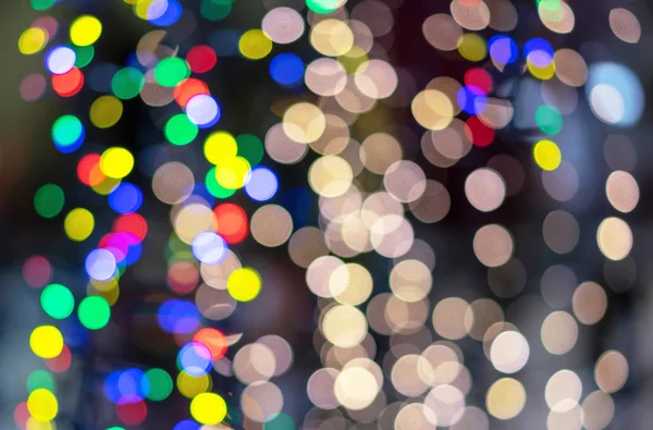 Defocused kerstslingers met kleurrijke gloed. Kerst achtergrond met veelkleurige bokeh. — Stockfoto