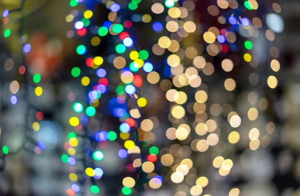 Defocused kerstslingers met kleurrijke gloed. Kerst achtergrond met veelkleurige bokeh. — Stockfoto