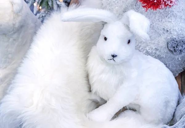 Soft toy of a white rabbit on white fur. — Stock Photo, Image