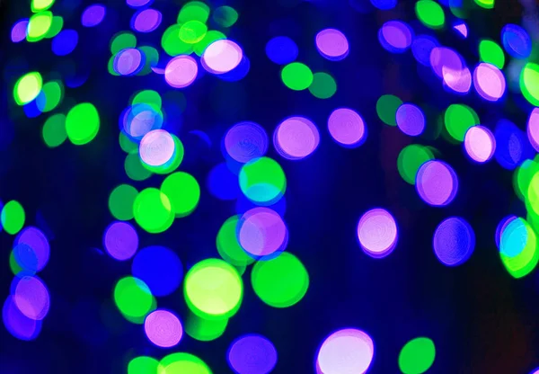 Defocused kerstslingers met kleurrijke gloed. Kerst achtergrond met veelkleurige bokeh. — Stockfoto