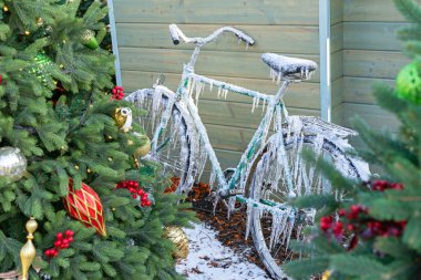 Evin duvarında buz saçakları olan donmuş retro bisiklet duruyor..