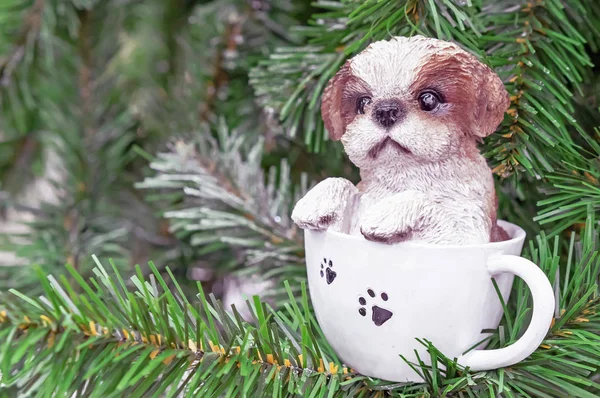 Ceramic figurine of a little puppy sitting in a white cup. — Stock Photo, Image