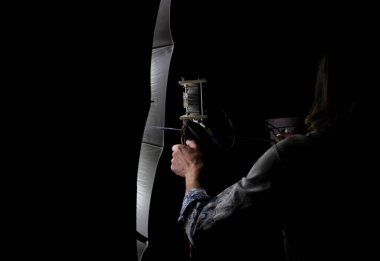 Fotoğrafçı bir fotoğraf stüdyosunda ışıklandırmayı ayarlıyor. Stüdyo ışıklandırması için fotoğraf şemsiyesi.