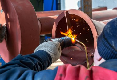 Kaynakçı yeni bir gaz boru hattındaki metal yapıları kaynaklıyor..