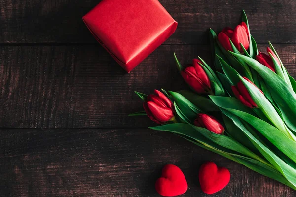 Μπουκέτο κόκκινες τουλίπες σε ξύλινο φόντο. Ανοιξιάτικα λουλούδια Ιστορικό της ημέρας της μητέρας. — Φωτογραφία Αρχείου