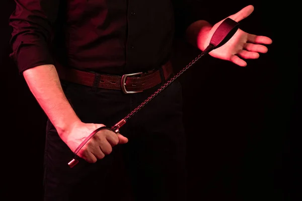 Erkek eli siyah deri kamçı tutuyor. kırbaç