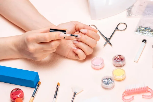 Mãos de uma menina fazendo uma manicure em casa, mãos close-up. a vista do topo — Fotografia de Stock