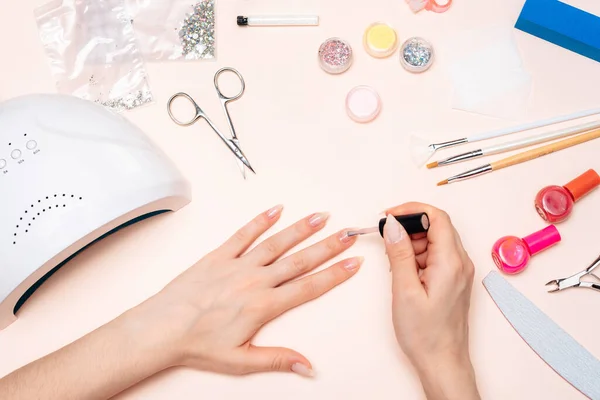 Mãos de uma menina fazendo uma manicure em casa, mãos close-up. a vista do topo — Fotografia de Stock