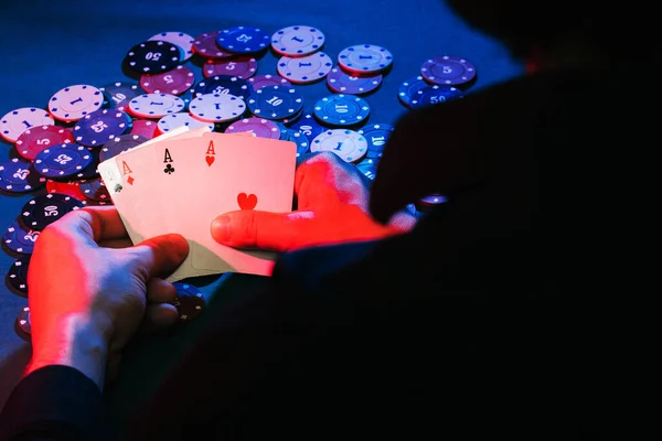 Mens mains tenir des cartes, un ensemble d'as sur le fond de jouer des jetons — Photo