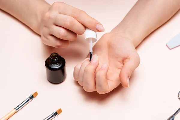 Mãos de uma jovem fazendo uma manicure. a vista do topo — Fotografia de Stock