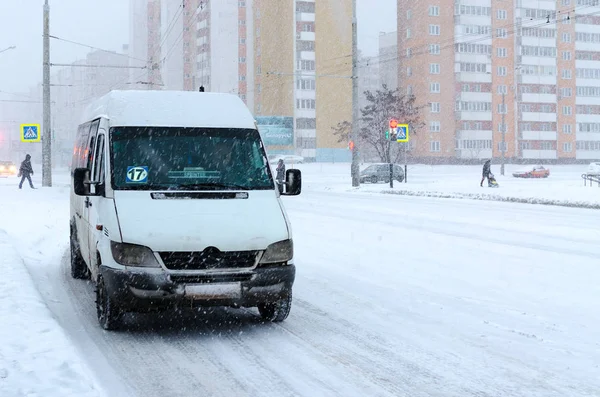 Маршрутное такси на городской улице во время сильного снегопада — стоковое фото