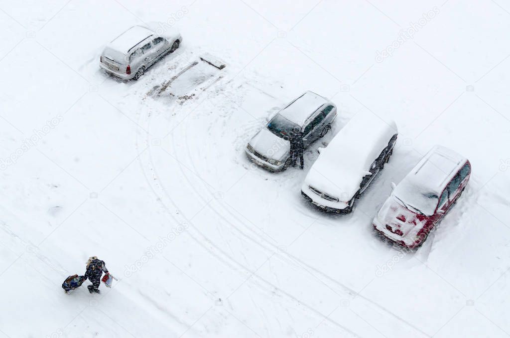 Top view of cars in courtyard during heavy snowfall 