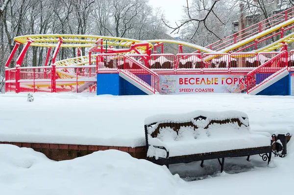 Atração nevado montanha-russa engraçado no parque de inverno durante a queda de neve — Fotografia de Stock
