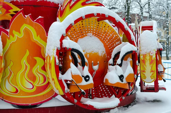 Снежный яркий разноцветный аттракцион в зимнем парке во время снегопада — стоковое фото