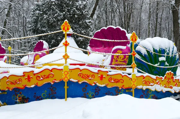 Atração multicolorida nevada no parque de inverno durante a queda de neve — Fotografia de Stock