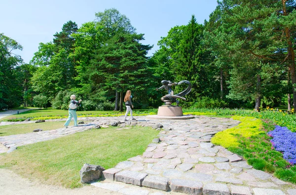 Tourists near sculpture Egle - Queen of snakes in Botanical park in Palanga, Lithuania — Stock Photo, Image