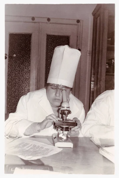 Студент медичного інституту розглядає підготовку під мікроскопом кафедри гістології (1987) — стокове фото