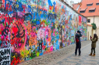 Turistler Çek Cumhuriyeti Prag 'daki John Lennon' un ünlü duvarındalar.