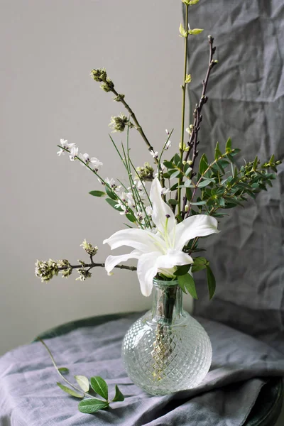 Natürmort bahar çiçekleri ve gri perdelik üzerinde beyaz zambak