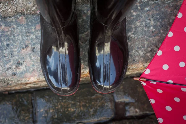 Siyah gumboots ve yağmurlu gün kırmızı şemsiye