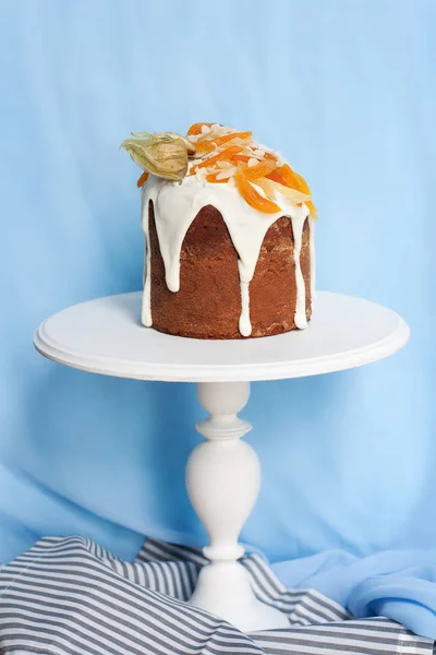 Şekerlenmiş meyve mavi zemin üzerine beyaz stand ile Paskalya kek dekore