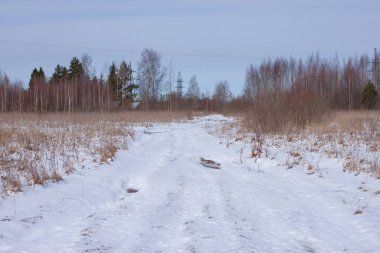 Karla kaplı bir tarlada geçilemez bozuk bir yol.