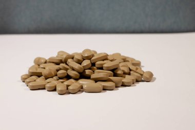 Beyaz arka planda bir sürü kahverengi hap var.