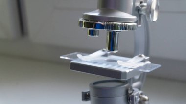 Pencereden güneş ışığı altında gümüş mikroskop