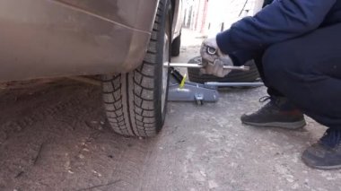 Arabanın tekerleğini değiştiriyorum. vidaları sökmek ve fındıkları sıkmak.