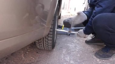 Arabanın tekerleğini değiştiriyorum. Arabayı krikoyla kaldırmak.