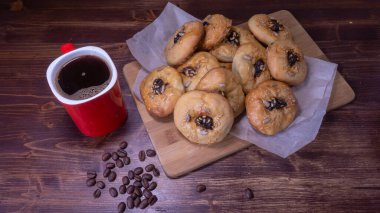 Kurabiye ve kahve çekirdekli kırmızı kahve kupası.