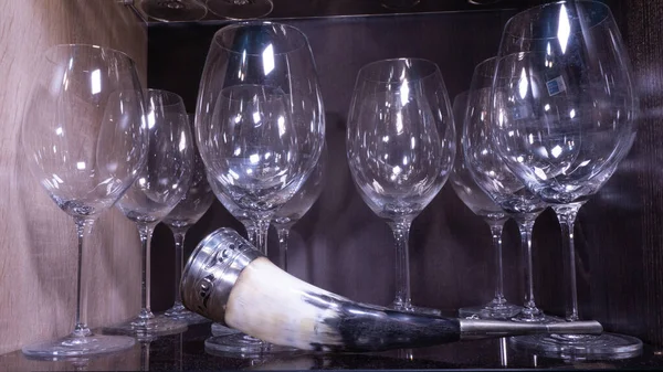 Wine horn with glass glasses on the shelf