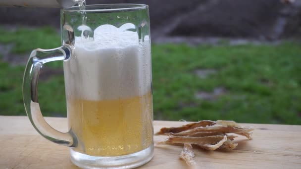 Schuim Licht Bier Wordt Gegoten Een Mok Natuur Een Houten — Stockvideo