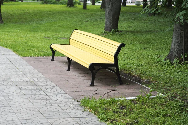 Panchina gialla solitaria nel parco cittadino . — Foto Stock