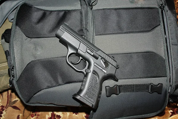 Pistolet na plecaku. — Zdjęcie stockowe
