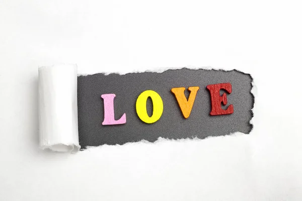 Ordet kärlek på en svart bakgrund och vit papper. — Stockfoto