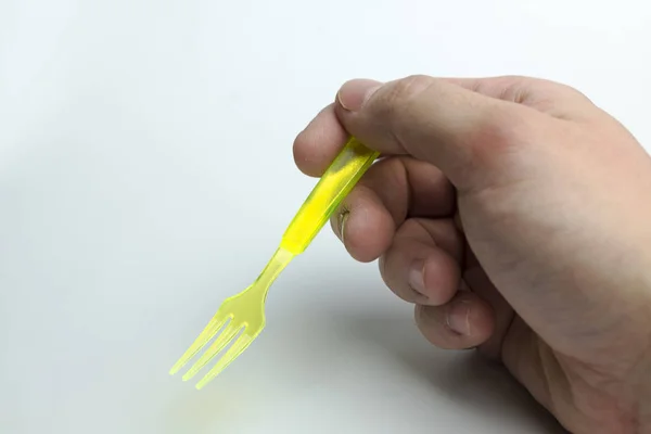 Mano sosteniendo un tenedor de plástico . —  Fotos de Stock