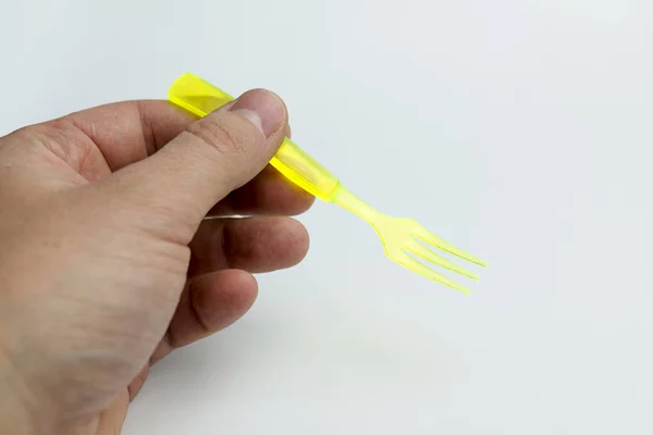 Main tenant une fourchette en plastique . — Photo
