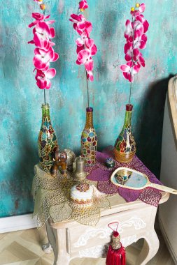 Şişe ve başucu masaya çiçek.