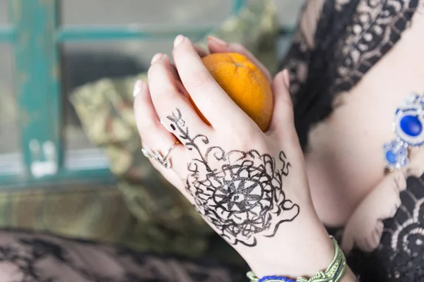 Joven chica mano sostiene un naranja . — Foto de Stock