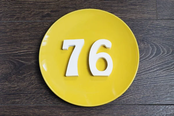 The number seventy-six on the yellow plate. — Stock Photo, Image