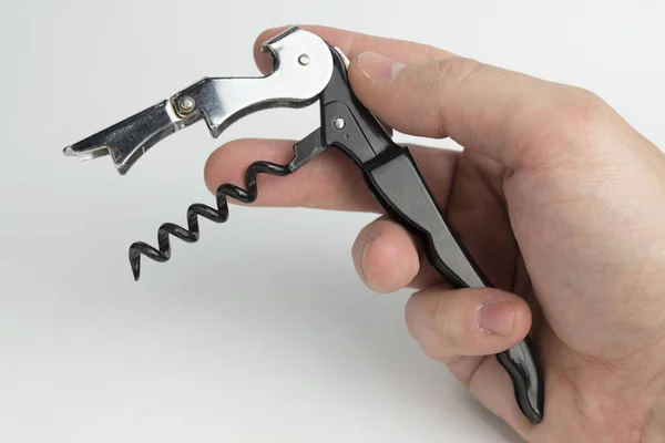 The hand holding the corkscrew on white background for wine bottles. — Stock Photo, Image
