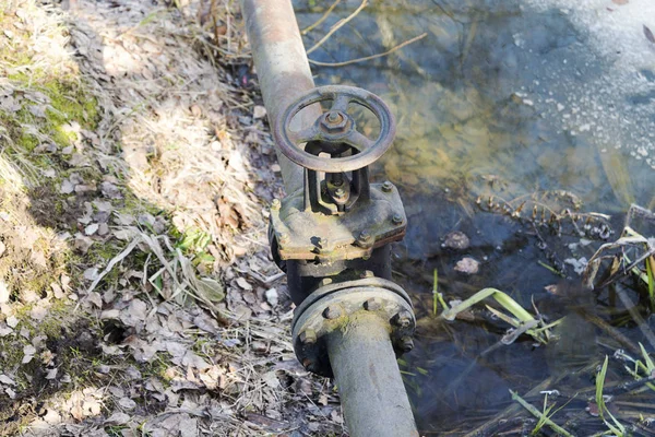 Клапан на трубе возле реки . — стоковое фото