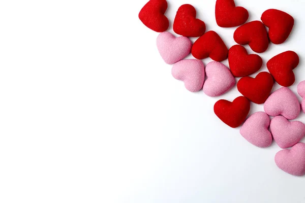 Många röda och rosa hjärtan på en vit bakgrund. — Stockfoto
