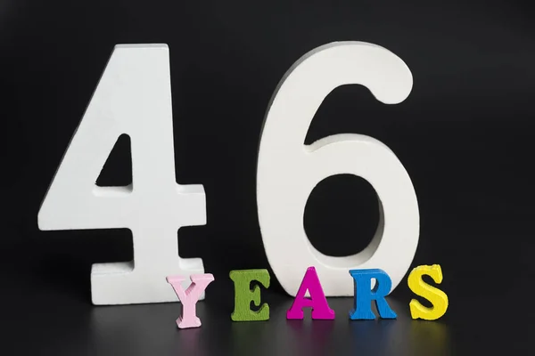 Buchstaben und Zahlen 46 Jahre auf schwarzem Hintergrund. — Stockfoto